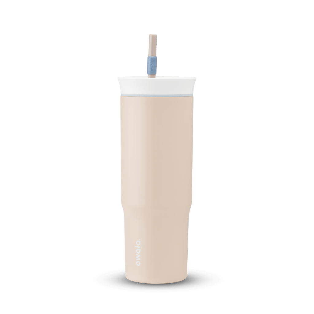 24oz Tumbler in Dune Drifter; matte sand-beige insulated tumbler with white lid, light gray accent ring, and tan straw with dusty blue grip, Owala wordmark on front